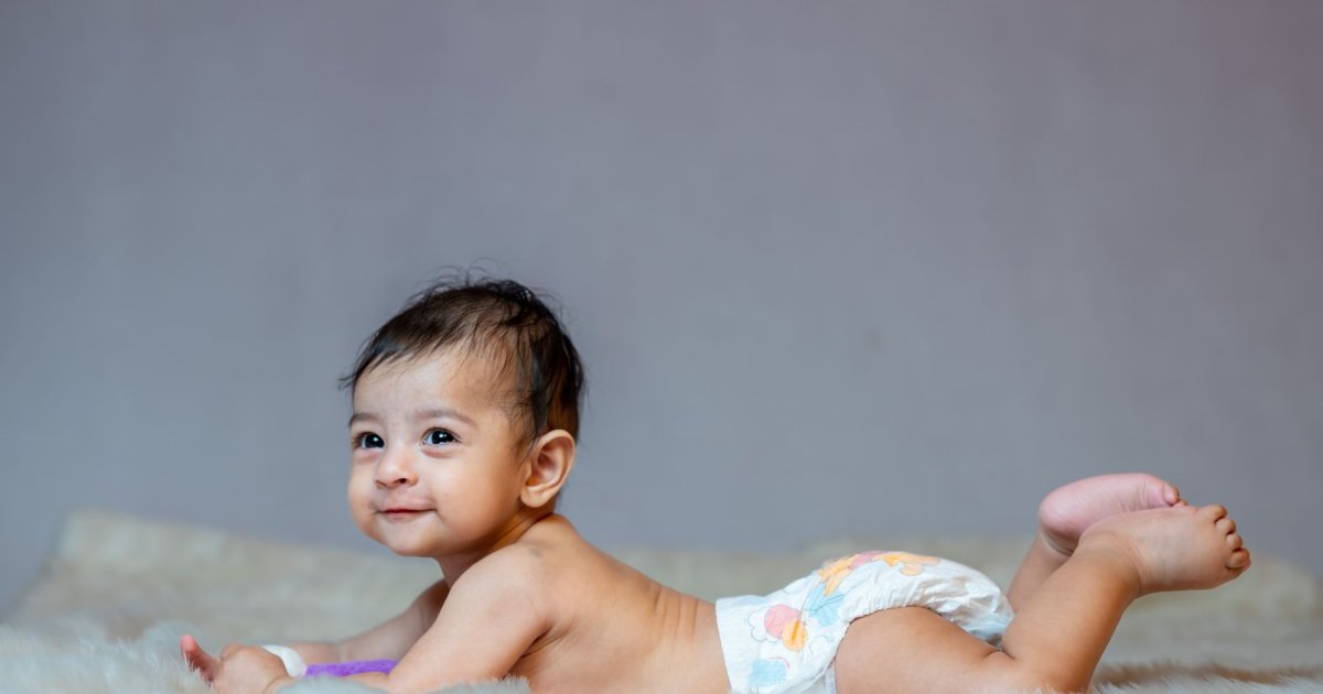 Una madre culla dolcemente il suo bambino nella penombra di una cameretta calda e rilassante per favorire il sonno.