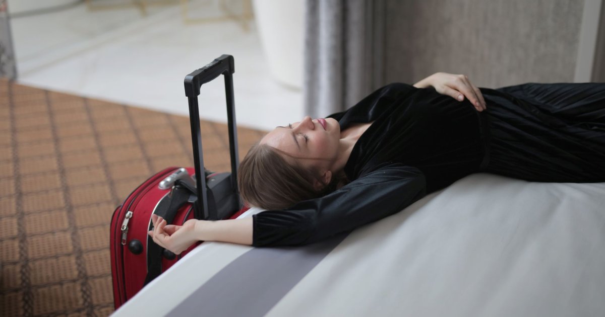 Viaggiatore in aereo che osserva l'alba dal finestrino, strategia per recuperare dal jet lag e regolare il ritmo circadiano.