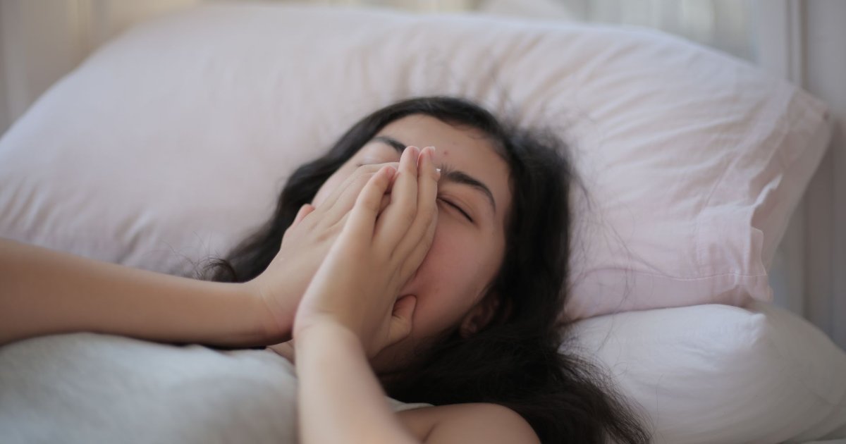 Uomo che dorme serenamente sul fianco per evitare la roncopatia cronica e migliorare il sonno