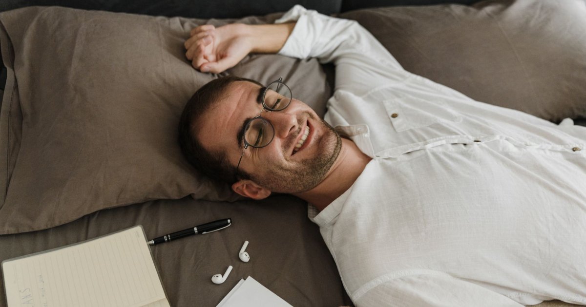 Uomo stanco alla scrivania che si tocca la testa, a dimostrazione del legame tra sonno e memoria concentrazione