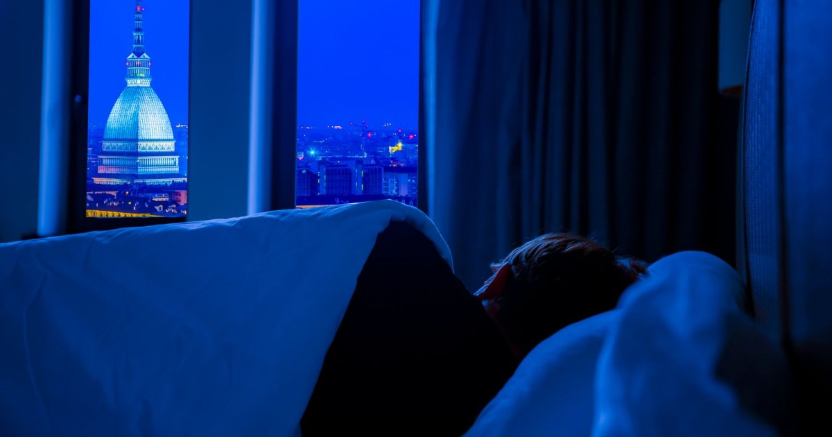Flaconi di integratori per il sonno naturali su un tavolo di legno accanto a una tazza di camomilla calda