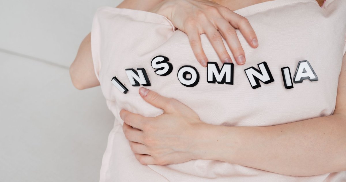 Donna a letto stressata che non riesce a dormire a causa del cortisolo alto la sera